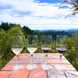a flight of wine staged on a brick surface; the santa cruz mountains in the background